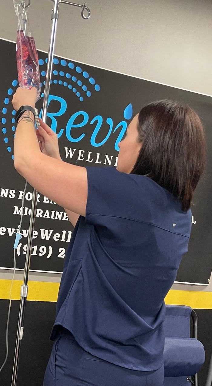 Lyndsay administering IV therapy to a patient at Revive Wellness NC